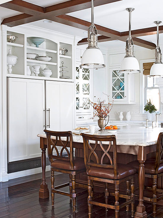 White Kitchen cabinets with marble island Chrome pendants and wood flooring www.pattersondecoratinggroup.com/blog
