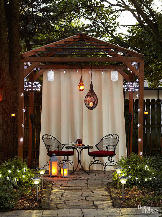 Outdoor curtains create a cozy private room for friends to gather at a bistro table and chairs www.PattersonDecoratingGroup.com/blog