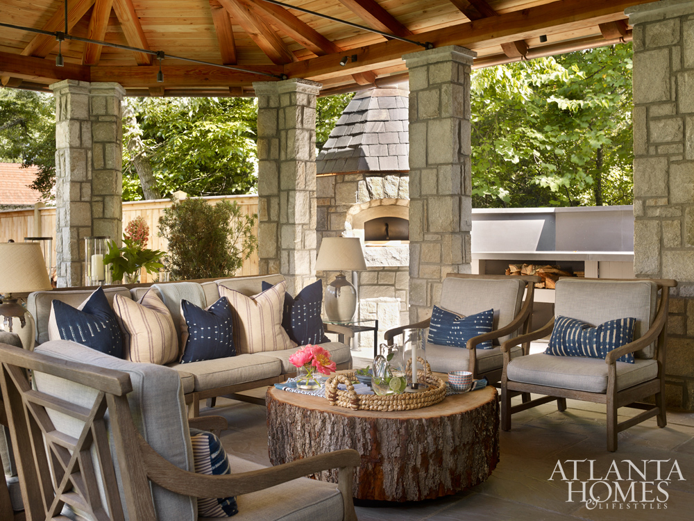 Rustic outdoor living room with stone and wood ceiling www.PattersonDecoratingGroup.com/blog