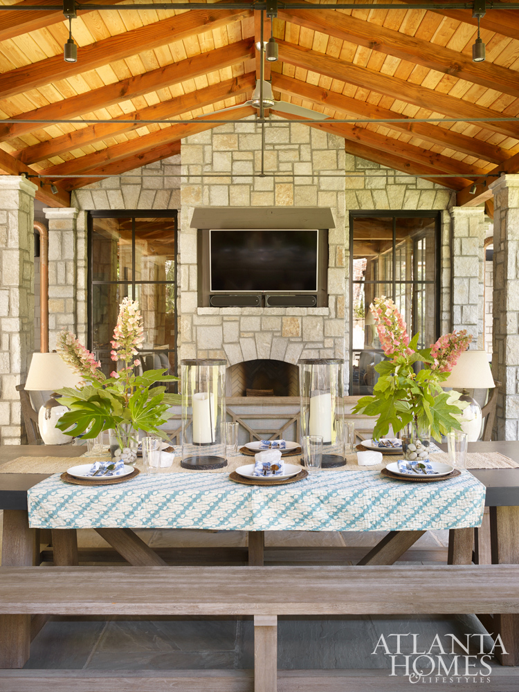 Outdoor dining space with stone fireplace and wood ceiling www.PattersonDecoratingGroup.com/blog