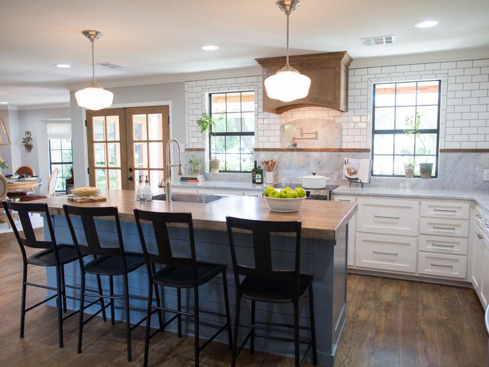 Expansive Kitchen by Fixer Upper with large painted island topped with a sentimental wooden counter made from the families’ bowling alley www.PattersonDecoratingGroup.com/blog