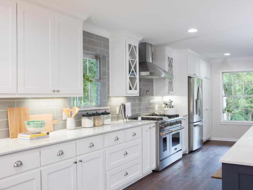 Fixer Upper Kitchen features white cabinetry with diamond shaped mullions that mirrors the original picture window in the living space www.PattersonDecoratingGroup.com/blog