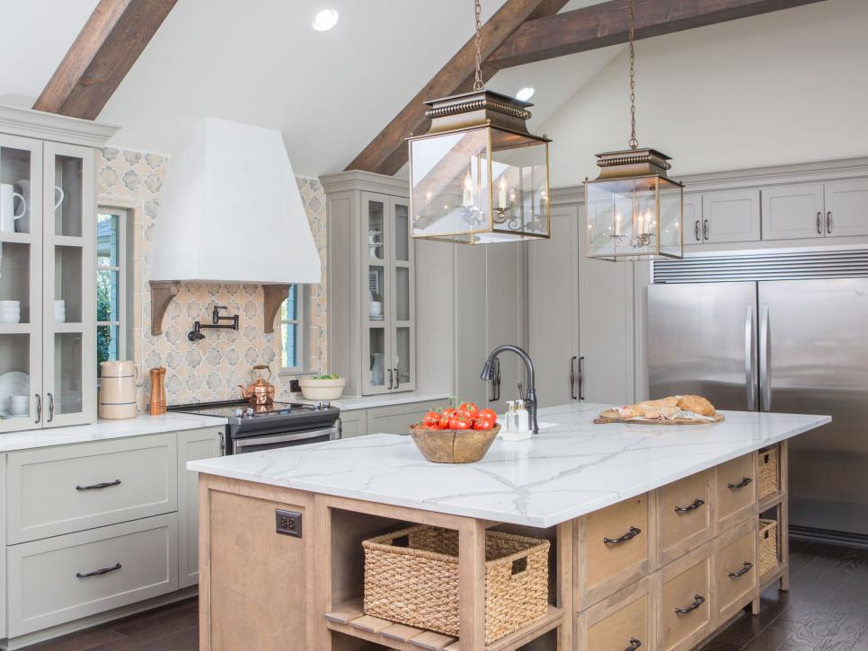 Fixer Upper kitchen with gray cabinets, wood tone island and pretty pendant lights along with a unique handmade backsplash tile www.PattersonDecoratingGroup.com/blog